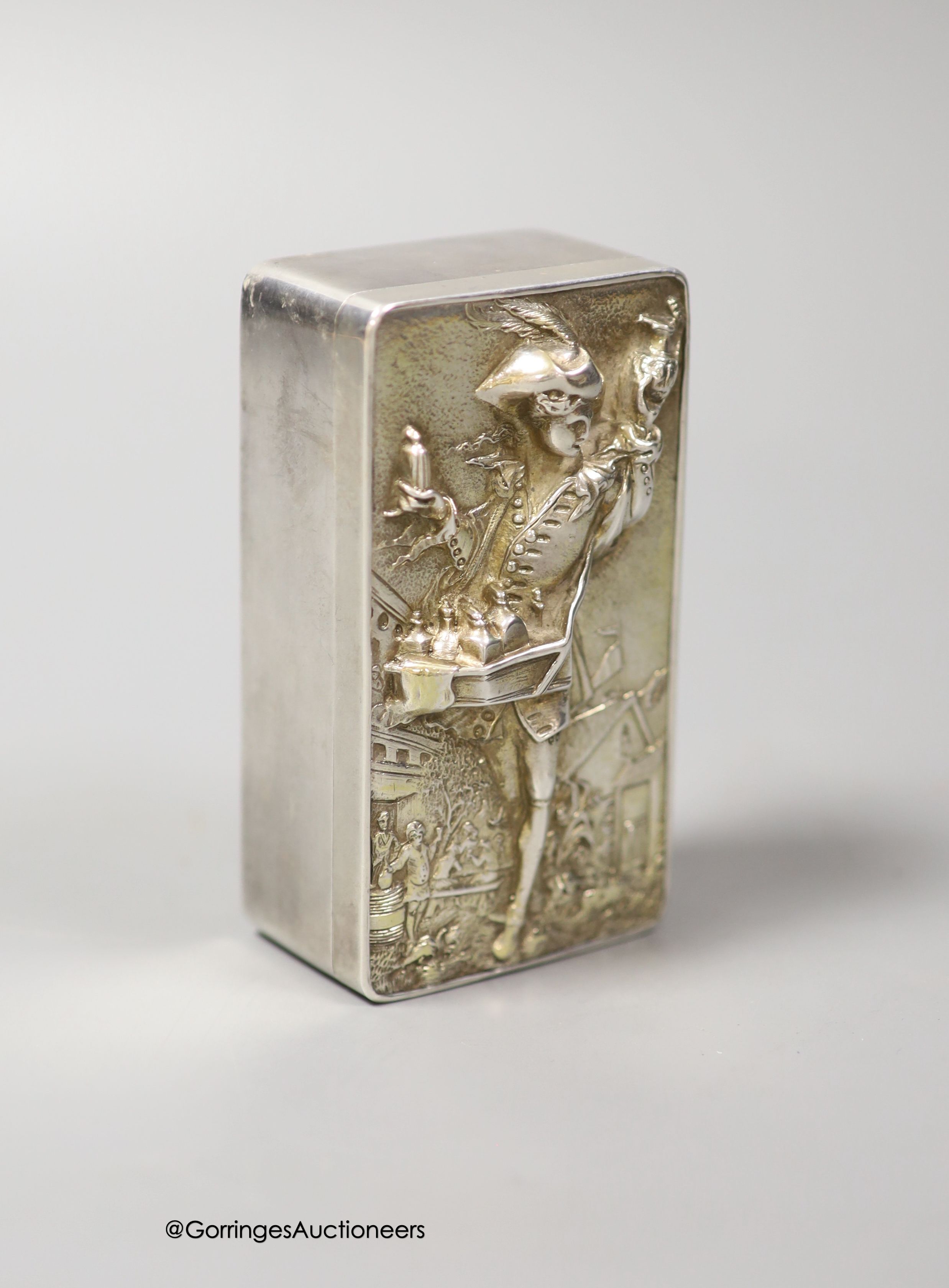 A late 19th/early 20th century continental white metal rectangular box and cover, the lid embossed with the figure of a pedlar, 9.5cm, 155 grams.